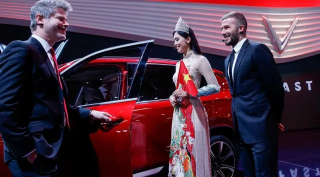 Vinfast director of design Dave Lyon, Miss Vietnam 2018 Tran Tieu Vy, and David Beckham at VinFast launch at the Paris Motor Show at Parc des Expositions.