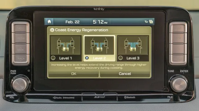 The 8-inch dashtop display explains battery regeneration levels. Note eight discrete buttons for audio on left, navigation on right. Plus discrete volume and tuning knobs.