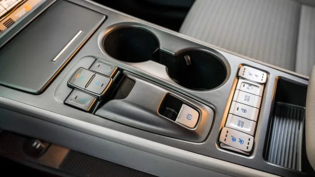 Kona EV console has the shifter buttons: Drive and Reverse left and right, Park and Neutral Up and Down. Note the front button on the bottom right: The Kona EV has seat heaters and seat cooler fans.