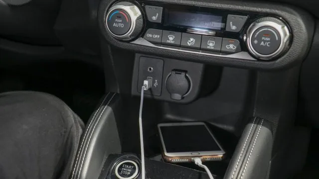 Стік центру Nissan Kicks включає в себе спеціальну панель клімат-контролю, USB-роз'єм, роз'єм для підключення лінії та 12-вольтовий роз'єм. Бездротова зарядка не пропонується.