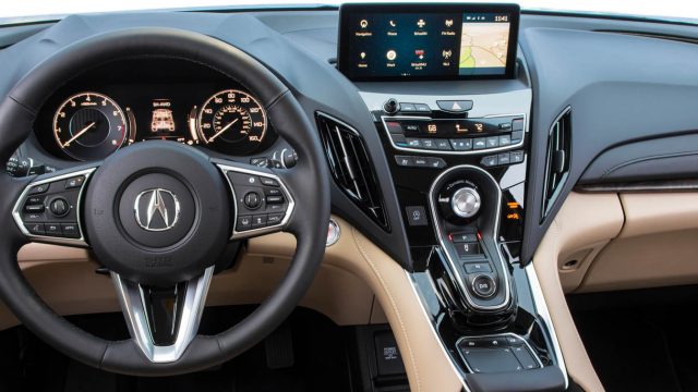 Центральный стек 2019 Acura RDX сверху: 10,2-дюймовый дисплей, специализированные контроллеры HVAC, селектор передачи, интерфейс True Touchpad, мягкий запястье.