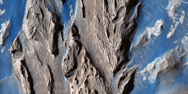 The long ridges and valleys are produced by wind erosion, leading to a build-up of dust across the planet.