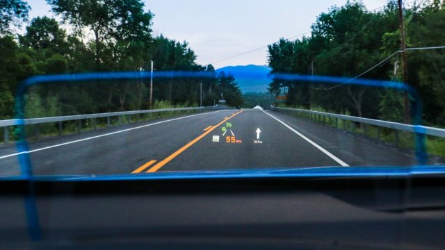 The Kona Ultimate includes a head-up display. It uses a collimator, a pop-up piece of mirrored plastic (see bluish outline) that reflects information in the driver’s line of sight. It’s simpler than a reflective patch on the windshield. Hyundai lets you change colors and set three speedometer sizes, although the largest (shown in orange at 55 mph) would be better at twice the size.