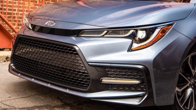 Toyota has four front-end treatments, all with trapezoidal 3D grille treatments. Sport (shown here) has Triple J-shape headlamp highlights, with accent lights low and flanking the grille. The Corolla L gets a darker grille called Modern. The Hybrid and Hatchback also get their own variants. 