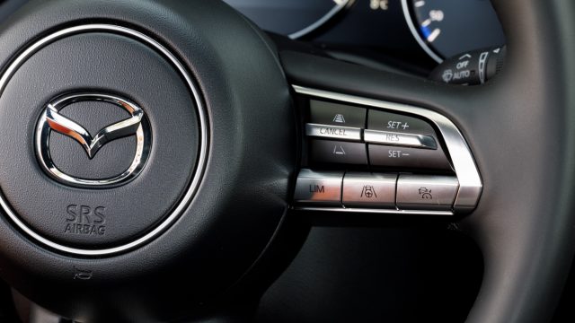 A new Mazda design for steering wheel switches: toggle up or down, or press. Older Mazdas had up-and-down rockers with a third button in between in the recessed vee. 