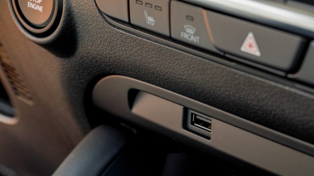 Five passengers share one USB jack in the center stack (here) and one in the console. Qi wireless charging is a dealer-installed option. 