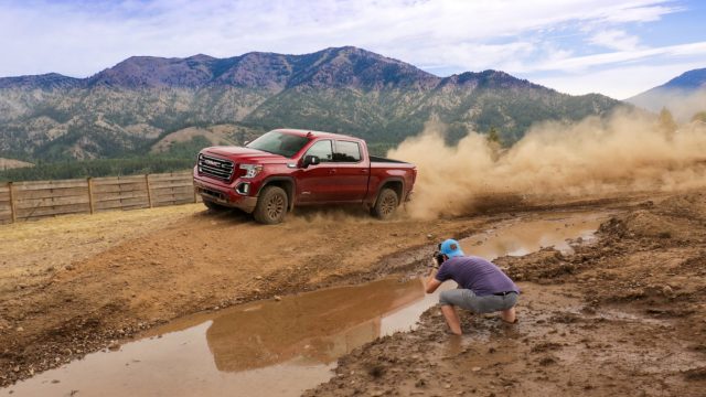 GMC Sierra AT4 бездорожье и поднимая грязь в Скалистых горах. Это делает для отличных фотографий. Обратите внимание, что фотограф погряз в грязи, приближаясь к отличному снимку…